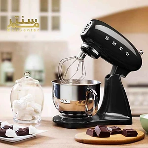یک همزن برقی مشکی رنگ SMEG با طراحی کلاسیک و کاسه استیل در حال هم زدن مواد غذایی.